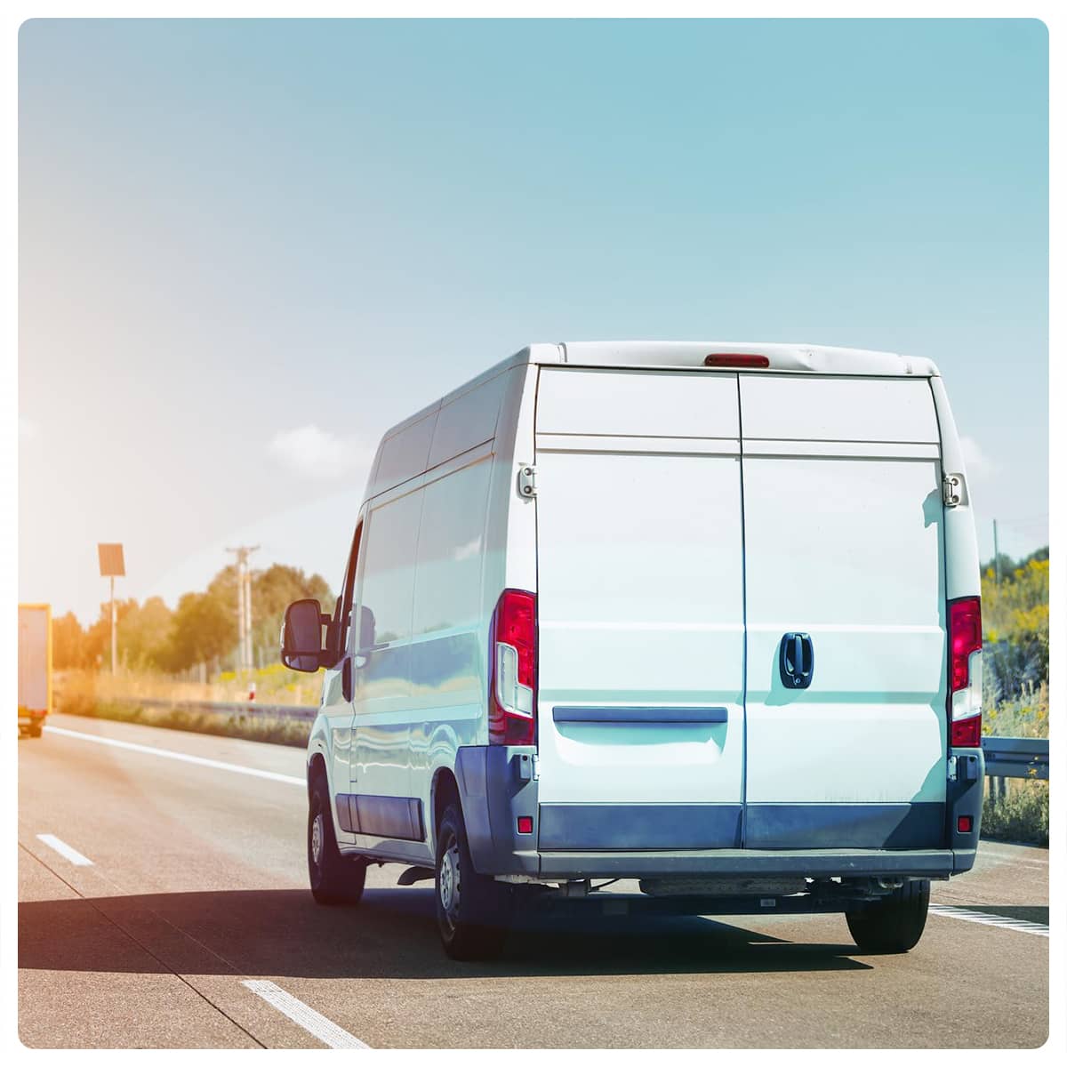 Biały dostawczak do 3,5 t z tachografem na drodze